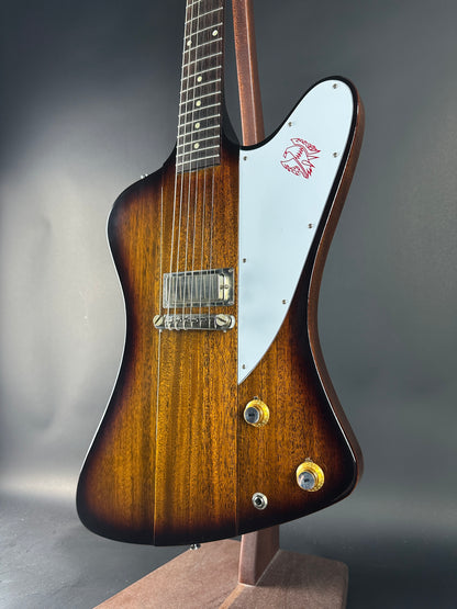 Wooden electric guitar with a white pickguard on a gray background