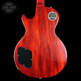 The back of a Gibson Les Paul Custom electric guitar with a glossy red cherry wood finish, featuring a black pickguard and a silver 'Gibson' logo badge on a black background.