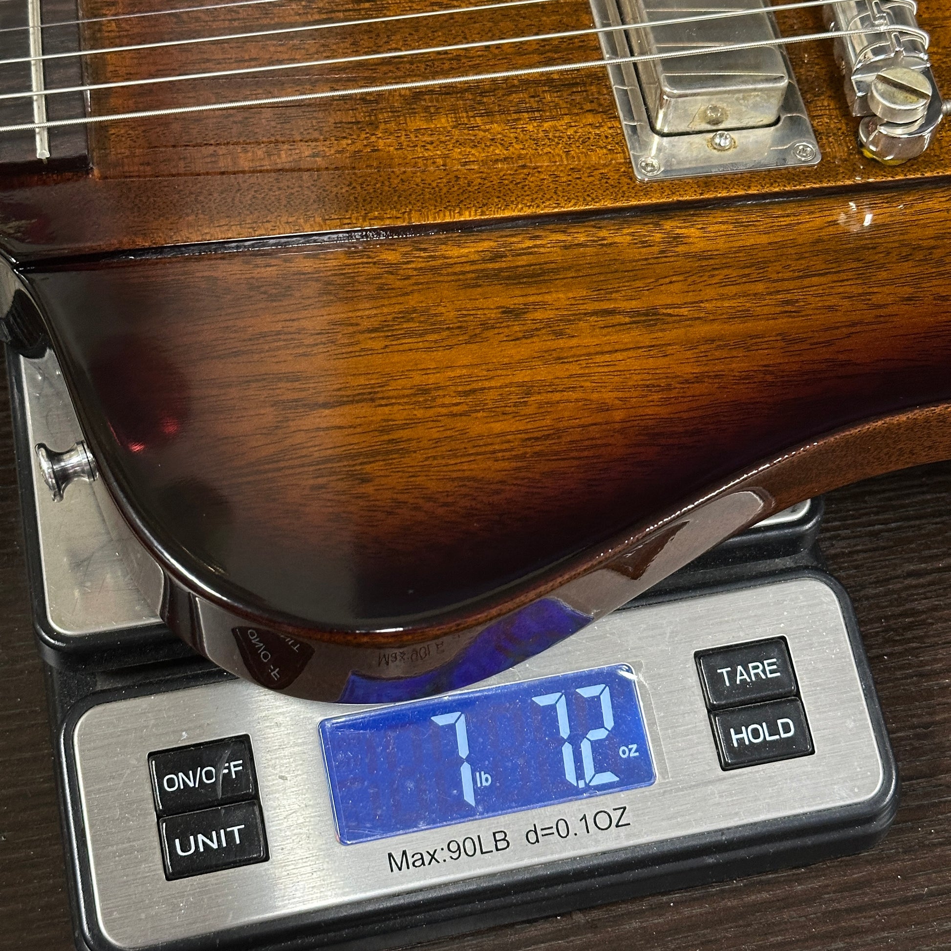 Guitar on a digital scale displaying weight