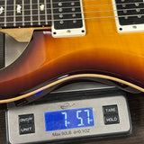 Electric guitar on a digital scale displaying weight