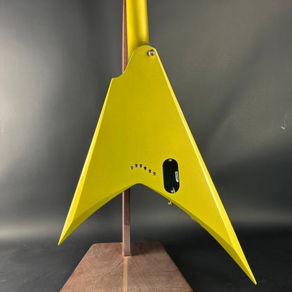 Yellow guitar body on a stand against a dark background