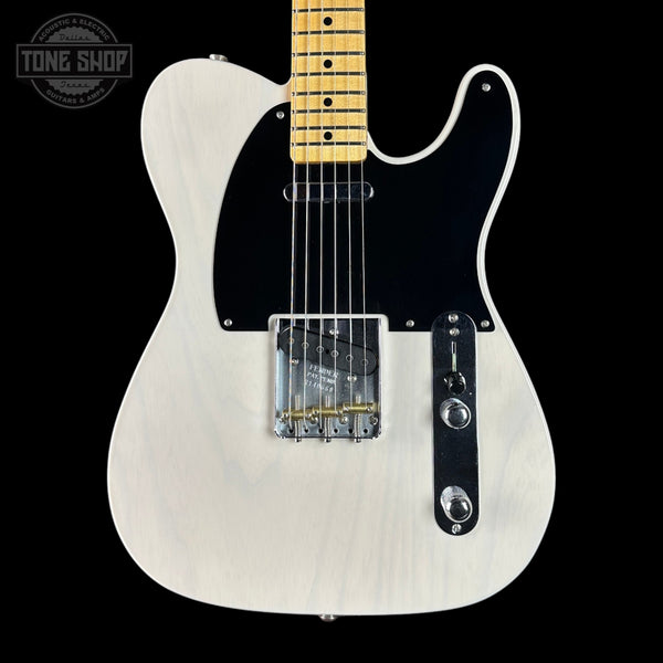 White electric guitar with a black pickguard on a black background, featuring the Tone Shop logo.
