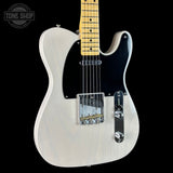 White electric guitar with a black pickguard on a black background, featuring 'Tone Shop' branding.