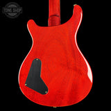 Red electric guitar body with a black pickguard on a black background, featuring 'Tone Shop' logo.