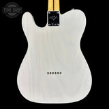 Back of a white electric guitar with a visible brand logo on a black background