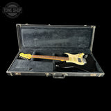 Electric guitar in a black case with 'Tone Shop' logo.