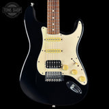 Black electric guitar with cream pickguard on a black background, featuring 'Tone Shop' logo.