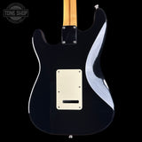 Black electric guitar with flame pattern on a black background, featuring the Tone Shop logo.