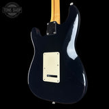 Black electric guitar with a visible brand logo on a black background
