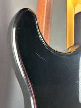 Close-up of a guitar's neck and headstock with a dark finish.