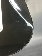 Close-up of a black car mirror with visible scratches on a gray background