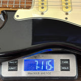 Guitar on a digital scale displaying weight
