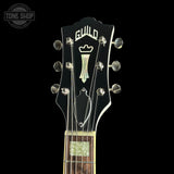 Guitar headstock with Guild logo on a black background