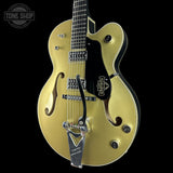 Gold electric guitar with a black pickguard on a black background, featuring the Troy Gentry logo.