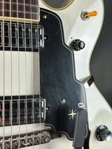 Close-up of a guitar's neck and headstock with visible wear.
