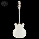 White electric guitar on a black background with 'Tone Shop' logo.