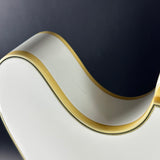 White ceramic dish with gold rim on a dark background