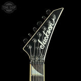 Close-up of a Jackson electric guitar headstock and neck against a black background, with a Tone Shop watermark in the upper left corner.