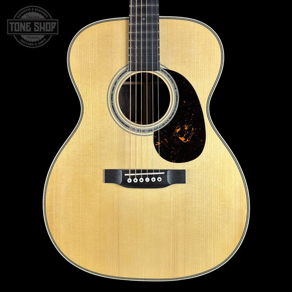 Acoustic guitar with a visible brand logo on a black background