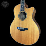 A close-up of a wooden acoustic-electric guitar body with a natural flamed maple finish, black bridge, and dark side cutaway, shown against a black background with a Tone Shop watermark in the top left.