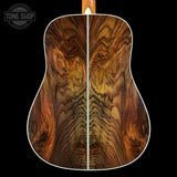Close-up of a guitar's wooden back with a visible brand logo in the corner.