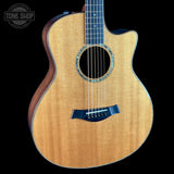 A cutaway acoustic-electric guitar with a natural wood finish and dark blue hardware, shown against a solid black background with a Tone Shop watermark in the top left corner.