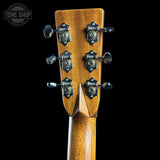 Close-up of a guitar headstock with tuning pegs on a black background, featuring the Tone Shop logo.