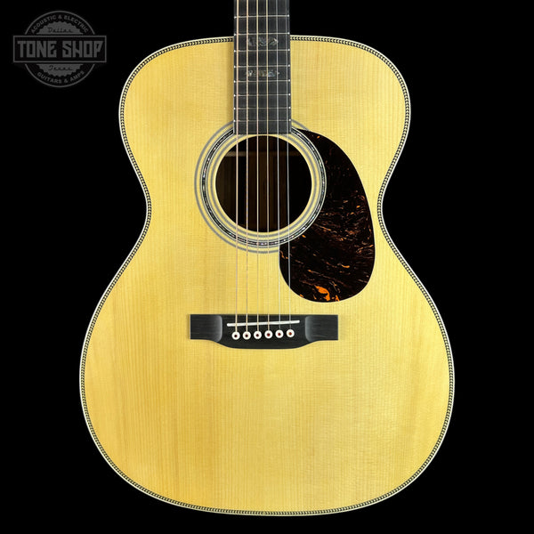 Acoustic guitar with a visible brand logo on a black background