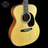 Acoustic guitar with a visible brand logo on a black background