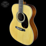 Acoustic guitar with a visible brand logo on a black background