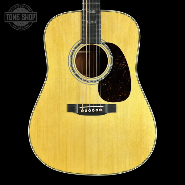 Acoustic guitar with a visible brand logo on a black background