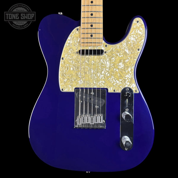 A close-up of a purple electric guitar body with a gold pearlescent pickguard, black hardware, and a maple neck, shown against a black background with a Tone Shop watermark in the top left.