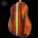 Close-up of a wooden acoustic guitar with a visible brand logo in the corner.