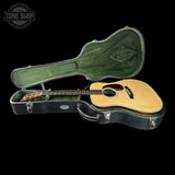 Acoustic guitar in a green case with 'Tone Shop' logo.