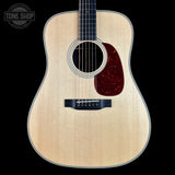 Acoustic guitar with a visible brand logo on a black background