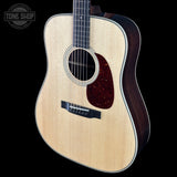 Acoustic guitar with a visible brand logo on a black background