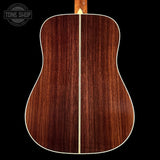 Back view of a wooden acoustic guitar with 'Tone Shop' logo.