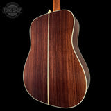 Back view of a wooden acoustic guitar with 'Tone Shop' logo.