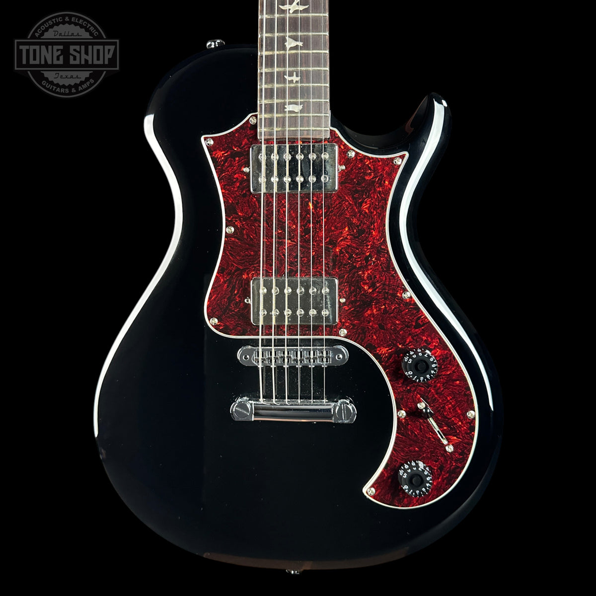 A black electric guitar with a red glittery pickguard and white binding, shown against a black background with a Tone Shop watermark in the top left corner.