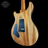 Wooden electric guitar body with a visible brand logo in the corner.