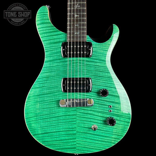 A green electric guitar with a flamed maple top and black hardware, shown against a solid black background with a Tone Shop watermark in the upper left corner.