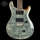 A double-cutaway electric guitar with a distinctive wavy, textured light gray and white flamed maple top, black hardware, and a dark brown fretboard, shown against a solid black background.