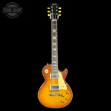Electric guitar with a sunburst finish on a black background, featuring the Gibson logo.