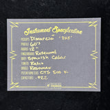 A gray rectangular card with yellow decorative border lines and handwritten text reading 'Instrument Specification' followed by details such as pickups, profile, radius, fingerboard, body, tuners, bridge, potentiometers, and capacitors. A small 'Rock & Roll Records All In House Design' logo appears at the bottom.