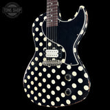 A black electric guitar with a bold cream polka-dot pattern, shown against a solid black background. The brand logo 'TONE SHOP' is visible as an overlay in the top-left corner.