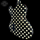A black electric guitar body with a distressed cream polka dot pattern, shown against a solid black background with a Tone Shop watermark in the top left corner.