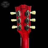 Close-up of a red guitar headstock with tuning pegs on a black background, featuring 'Tone Shop' branding.