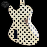 A double-cutaway electric guitar body cover or custom headstock backplate featuring a cream-colored distressed finish with a bold black polka dot pattern, shown against a solid black background.