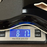 Digital scale displaying weight with a blue screen on a wooden surface