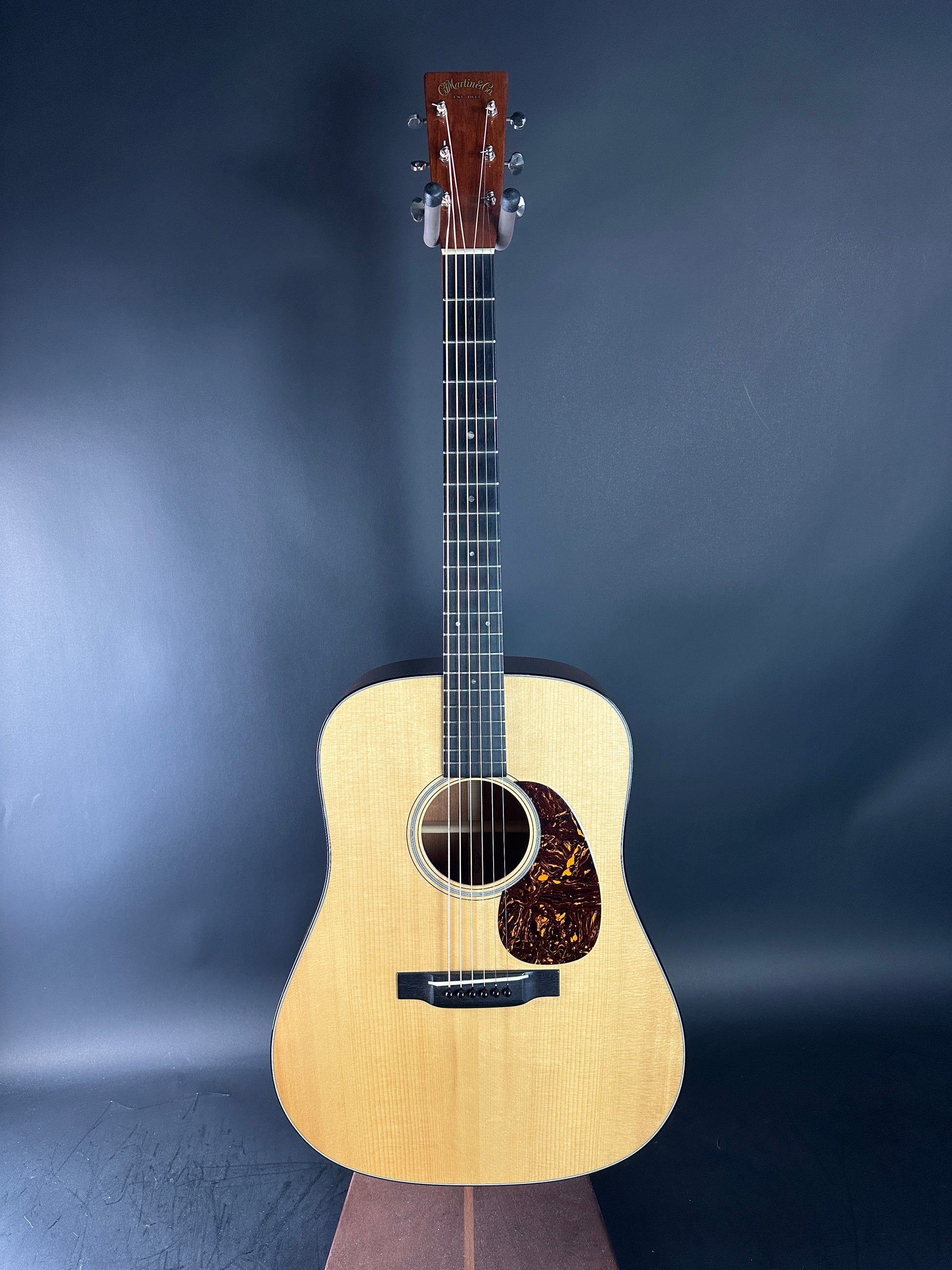 Acoustic guitar on a dark blue gradient background